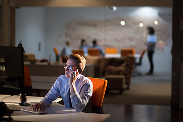 Image showing man using mobile phone in dark office