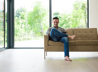 Image showing man on sofa using tablet computer