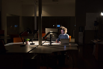 Image showing man working on computer in dark office