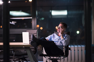 Image showing businessman using mobile phone in dark office
