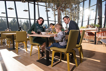 Image showing Young parents enjoying lunch time with their children