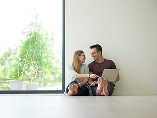 Image showing couple using laptop on the floor at home