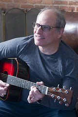 Image showing middle age senior man playing guitar