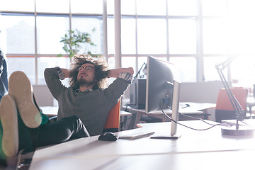 Image showing businessman sitting with legs on desk