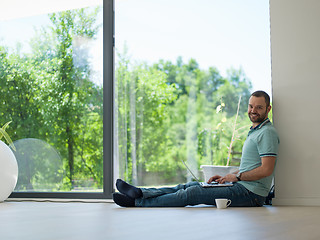 Image showing man drinking coffee on the floor enjoying relaxing lifestyle