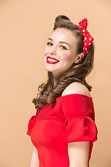 Image showing Beautiful young woman with pinup make-up and hairstyle. Studio shot on pastel background