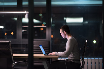 Image showing man working on laptop in dark office