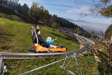 Image showing mother and son enjoys driving on alpine coaster