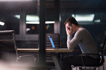 Image showing man working on laptop in dark office