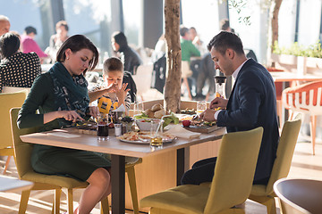 Image showing Young parents enjoying lunch time with their children