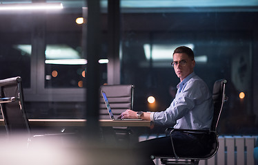 Image showing man working on laptop in dark office