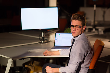 Image showing man working on computer in dark office