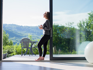 Image showing woman eating breakfast in front of her luxury home villa