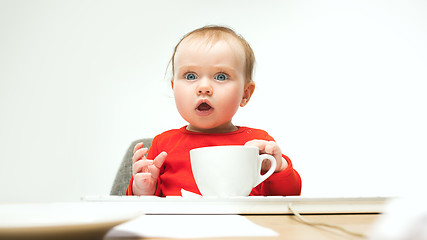 Image showing Happy child baby girl toddler sitting with keyboard of computer isolated on a white background