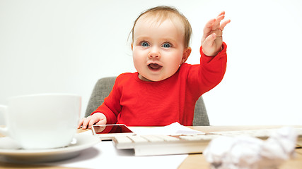 Image showing Happy child baby girl toddler sitting with keyboard of computer isolated on a white background