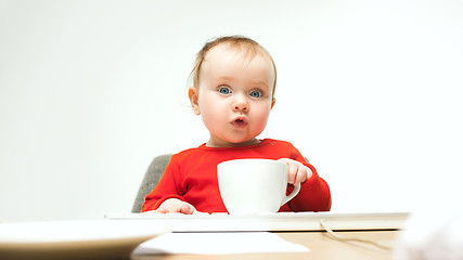 Image showing Happy child baby girl toddler sitting with keyboard of computer isolated on a white background