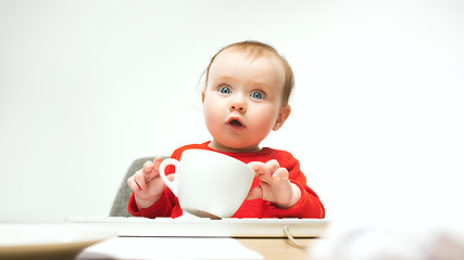 Image showing Happy child baby girl toddler sitting with keyboard of computer isolated on a white background