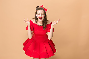 Image showing Beautiful young woman with pinup make-up and hairstyle. Studio shot on pastel background