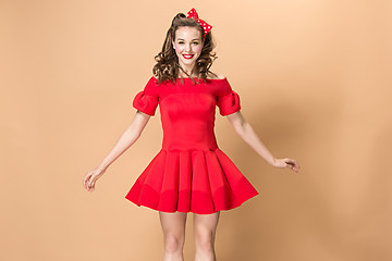 Image showing Beautiful young woman with pinup make-up and hairstyle. Studio shot on pastel background