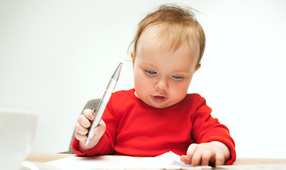 Image showing Happy child baby girl toddler sitting with keyboard of computer isolated on a white background