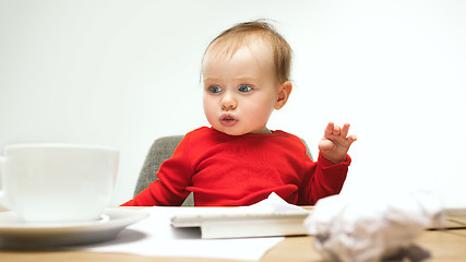 Image showing Happy child baby girl toddler sitting with keyboard of computer isolated on a white background