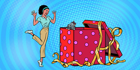 Image showing dog puppy holiday gift box. African woman funny reaction joy