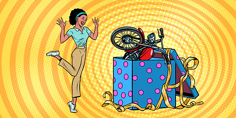 Image showing motorcycle holiday gift box. African woman funny reaction joy