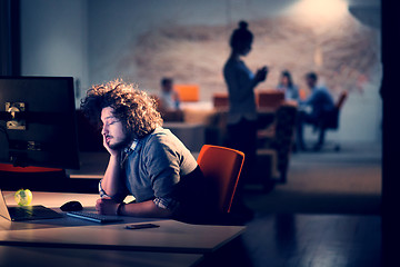 Image showing man working on computer in dark office