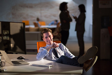 Image showing businessman sitting with legs on desk at office