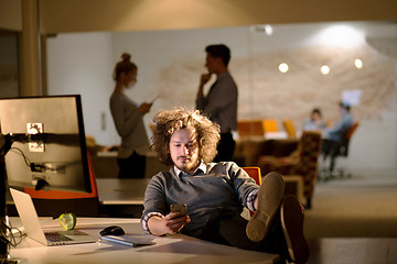 Image showing businessman sitting with legs on desk at office