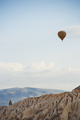 Image showing Hot air balloon flying over the rocky land