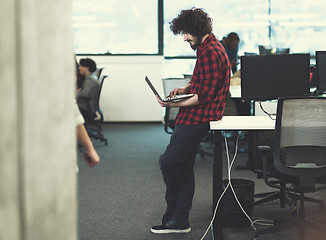 Image showing smiling male software developer using laptop