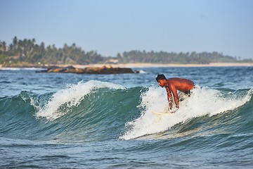 Image showing Young man surfing in sea