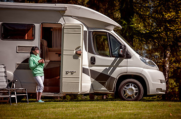 Image showing Woman is standing with a mug of coffee near the camper RV.