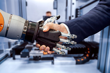 Image showing Hand of a businessman shaking hands with a Android robot.