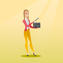 Image showing Smiling woman holding an open clapperboard.