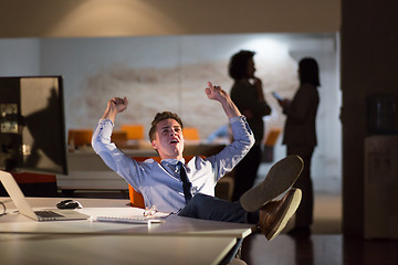 Image showing businessman sitting with legs on desk at office