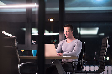 Image showing man working on laptop in dark office