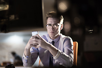 Image showing man using mobile phone in dark office