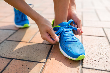 Image showing Woman fixing the shoelace