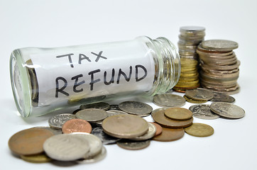 Image showing Tax refund lable in a glass jar with coins spilling out 