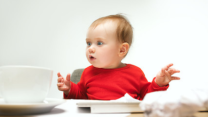 Image showing Happy child baby girl toddler sitting with keyboard of computer isolated on a white background