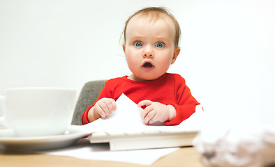 Image showing Happy child baby girl toddler sitting with keyboard of computer isolated on a white background