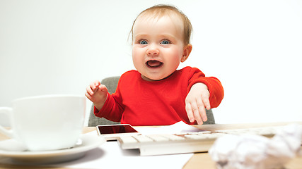 Image showing Happy child baby girl toddler sitting with keyboard of computer isolated on a white background