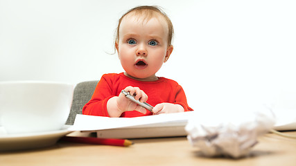 Image showing Happy child baby girl toddler sitting with keyboard of computer isolated on a white background