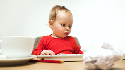 Image showing Happy child baby girl toddler sitting with keyboard of computer isolated on a white background