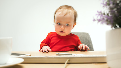 Image showing Happy child baby girl toddler sitting with keyboard of computer isolated on a white background