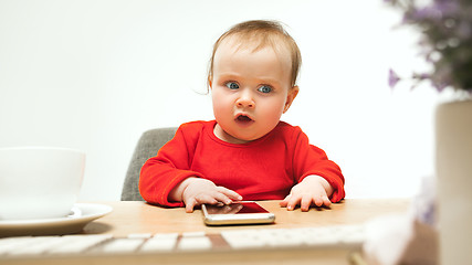 Image showing Happy child baby girl toddler sitting with keyboard of computer isolated on a white background