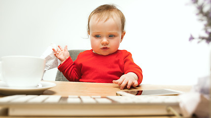 Image showing Happy child baby girl toddler sitting with keyboard of computer isolated on a white background