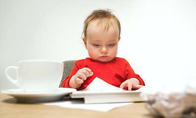 Image showing Happy child baby girl toddler sitting with keyboard of computer isolated on a white background